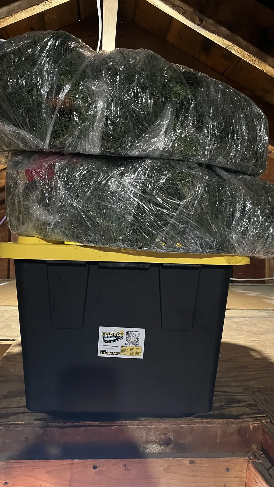 Holiday garland wrapped in plastic and stacked on a labeled storage tote in Massapequa after the season takedown